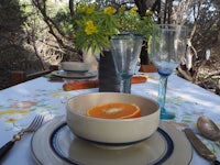 a table setting with a bowl of oranges and utensils