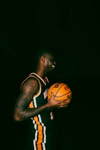 a basketball player holding a ball in the dark