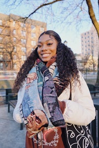 a young woman wearing a scarf in a park