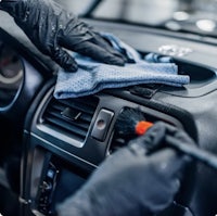 a person cleaning a car with a cloth
