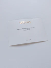 a white card with the word versace on it