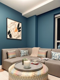 a living room with blue walls and a blue ottoman