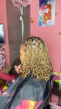 a woman is getting her hair braided in a salon