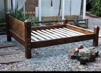 a wooden bed with slats in a garden