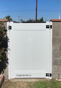 a white gate with a black handle on it