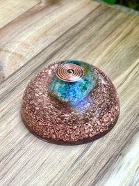 a copper and blue sphere sitting on top of a wooden table