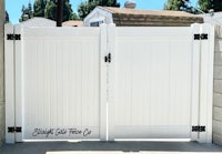 a white gate with a black handle on it