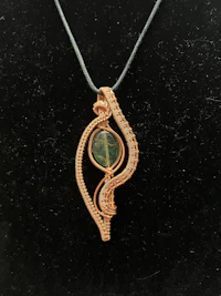 a wire wrapped pendant with a green stone