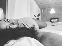 a black and white photo of a woman laying on a bed