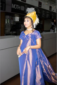 a woman in a blue dress with a feather