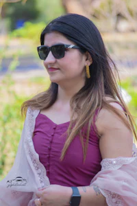 a woman wearing sunglasses and a pink dress