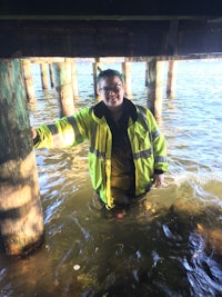 a man in a yellow jacket standing in the water
