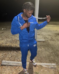 a man in a blue hoodie and track pants