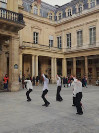 a group of men performing a dance in front of a building