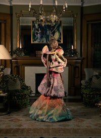 a woman in a colorful dress standing in a room