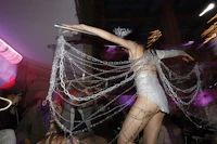 a woman in a white dress is dancing on a stage at a party
