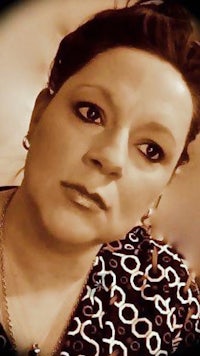 a woman in a black and white shirt looking at the camera