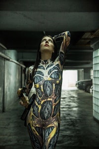 a woman in a body suit posing in a parking garage
