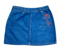 a blue denim skirt with a red flower on it