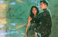 a man and woman standing next to each other in a dark room