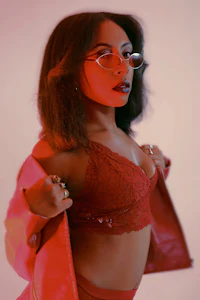 a woman in a red outfit with glasses posing