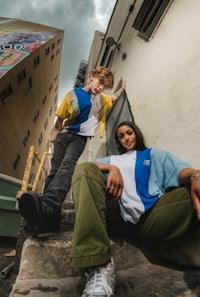 a man and a woman sitting on steps in front of a building