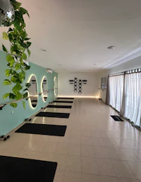 a yoga studio with a lot of plants and mirrors