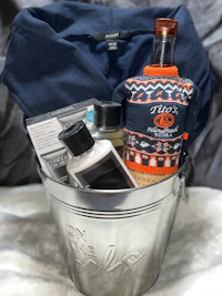 a bucket with a bottle of liquor and a sweater