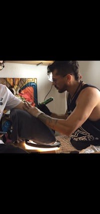 a man is getting a tattoo on his arm