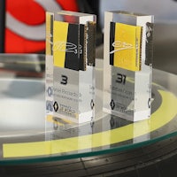 two trophies sitting on top of a glass table