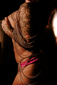 a woman with tattoos posing in a pink bikini