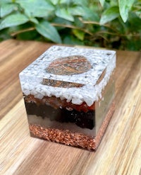 a glass cube with sand and rocks on it