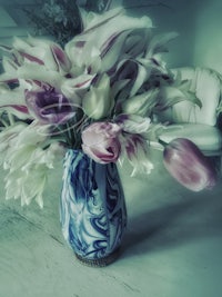 a blue vase with white and pink flowers in it
