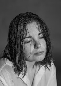 a black and white photo of a woman with her eyes closed