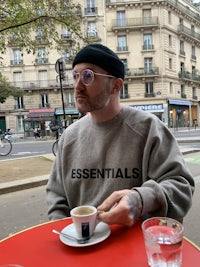 a man sitting at a table with a cup of coffee