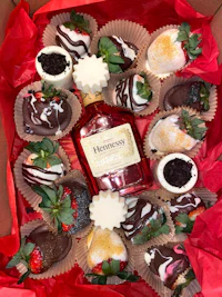 a box filled with chocolate covered strawberries and a bottle of bourbon