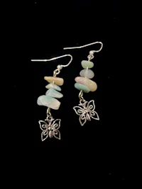a pair of earrings with butterfly charms on them