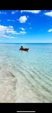 a person is paddling a red canoe in the water