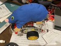 a blue stuffed animal sitting on top of a toy car