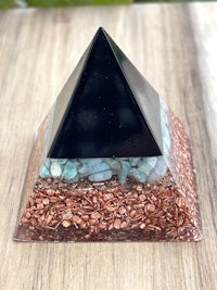 a black and copper pyramid on a wooden table