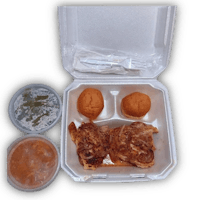 a box containing a chicken sandwich and a cup of sauce