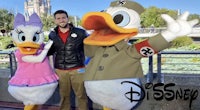 a man is posing with two donald duck mascots