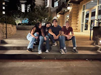 a group of people sitting on steps at night