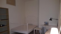 a small room with a bed and a desk