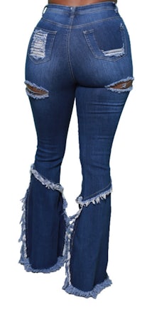 the back view of a woman wearing distressed jeans