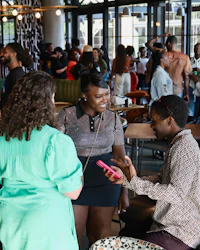 a group of people at a bar talking to each other