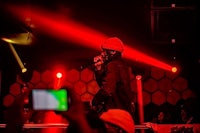 a man in a red hat is performing at a concert