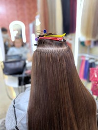 a woman's hair is being braided in a salon