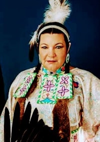 a woman in a native american outfit posing for a photo