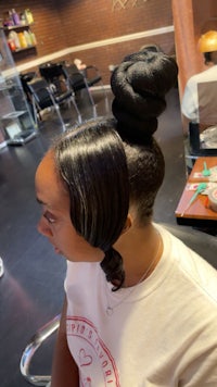 a woman in a salon with her hair in a bun